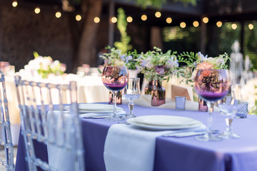 Flower table decorations for holidays and wedding dinner. Table set for holiday, event, party or wedding reception in outdoor restaurant.