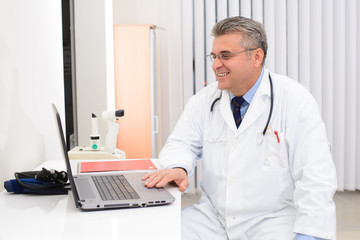 Doctor in his office with laptop