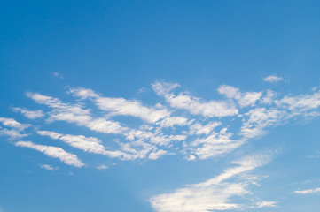 White fkuffy cloudy lines on the light-blue summery sky