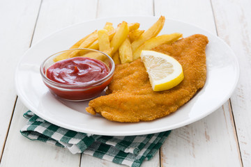 Wiener schnitzel with fried potatoes on white wooden background

