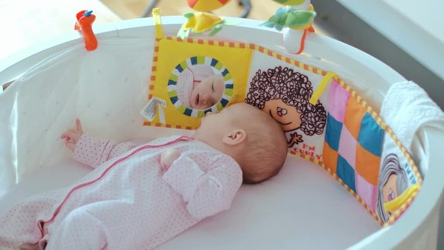Lovely newborn baby lying in a cradle. Beautiful newborn baby in crib