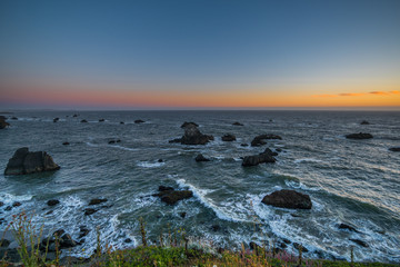 Marvellous sunset, amazing evening sky. Large boulder among the waves in the sea. Sonoma Coast State Park, California, USA