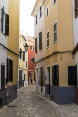 Fototapeta na wymiar Narrow street in old town in Menorca, Spain