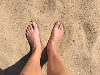 Füße stehen barfuß im Sand