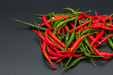 red and green chilli hot pepper on black background