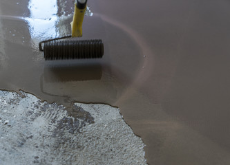 Interior of house under construction. Roller application. Floor