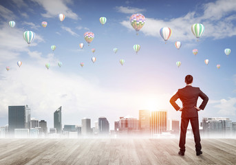 Motivation and inspiration concept with modern cityscape and businessman observing it