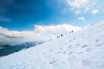 Hiking tourists climbs to the snow-capped mountain top. Concept theme: nature, weather, climbing,...