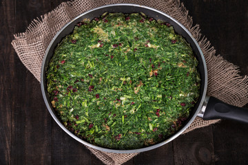 Persian Mixed herbs frittata with barberry and walnut in pan (Kuku and Zereshk) - obrazy, fototapety, plakaty