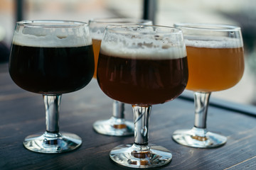 four glasses of beer on wooden table