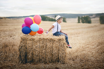 niño con globos en el campo
