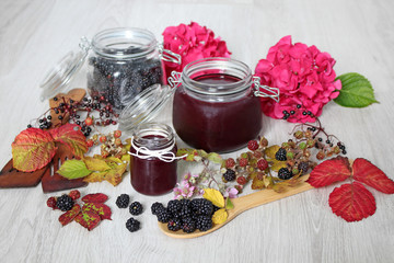 Fototapeta na wymiar Homemade blackberry jam in jars and autumn leaves