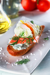 sandwich with ricotta cheese, salmon and poached egg on a plate