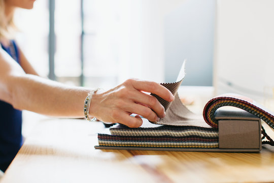Designer woman choosing textures from a sample book.