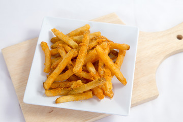 Hot and spicy french fries on a white plate with mayonnaise and cheese sauce