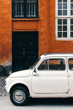 Old car parked in front of house wall