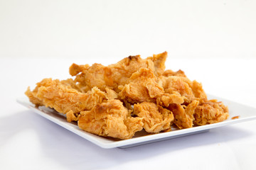 Fried crispy chicken breaded with corn flake crumbs with ketchup on wooden board.