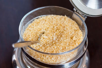 An old sugar bowl with spoon on dark background