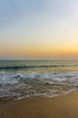 Menschenleerer Strand im pastellfarbenen Morgenlicht