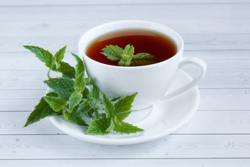 Cup of mint tea and a bunch of mint on the table