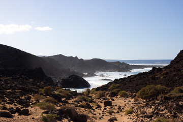 Panoramic ocean view. Volcano, black rocks. Sand macro. Sea background. Horizon.