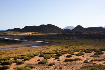 Panoramic ocean view. Volcano, black rocks. Sand macro. Sea background. Horizon.