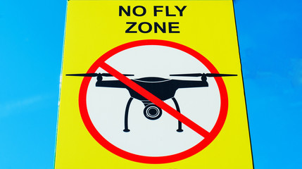 Signboard NO FLY ZONE  with a picture of a dithered droning.