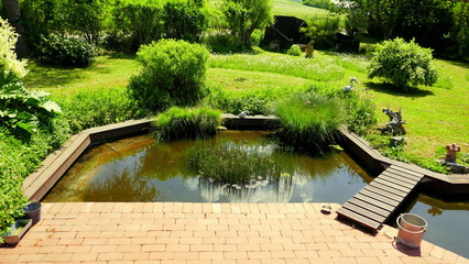 natürlicher Garten und schöner Teich an Terrasse angrenzend