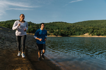 Two runners by a lake practising early in the morning