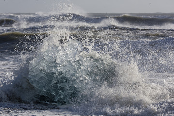 Blocks of ice from the glaciers break up and is washed ashore by the strong waves of the North Atlantic sea in Iceland.