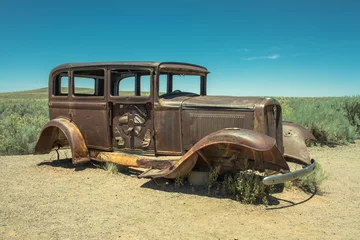 Rolgordijnen Route 66 Verlaten verroeste antieke auto in de buurt van geschilderde woestijn op Route 66