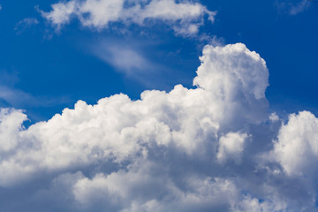 White cumulus clouds against a bright blue sky (background)