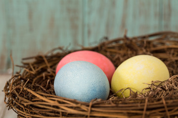 Close Up of Three Colorful Easter Eggs in a Nest