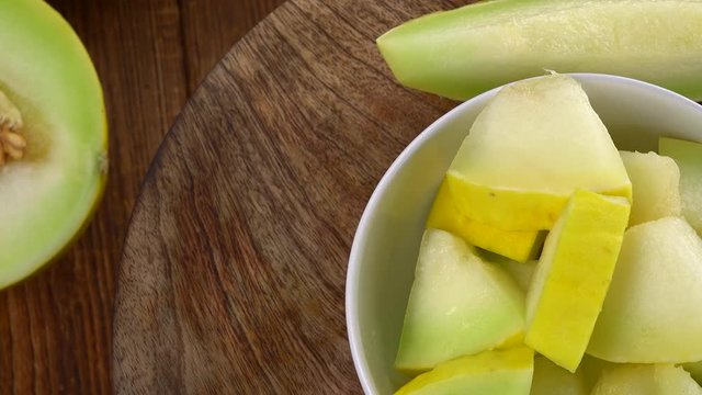 Honeydew Melon on a rotating wooden plate (seamless loopable; 4K)