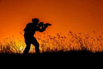 military soldier with weapons at sunset. shot, holding gun, colorful sky. military concept.