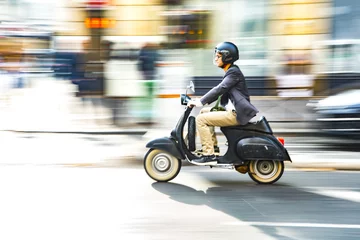 Foto op Plexiglas A man is riding a moped along the street © antonloshchinin