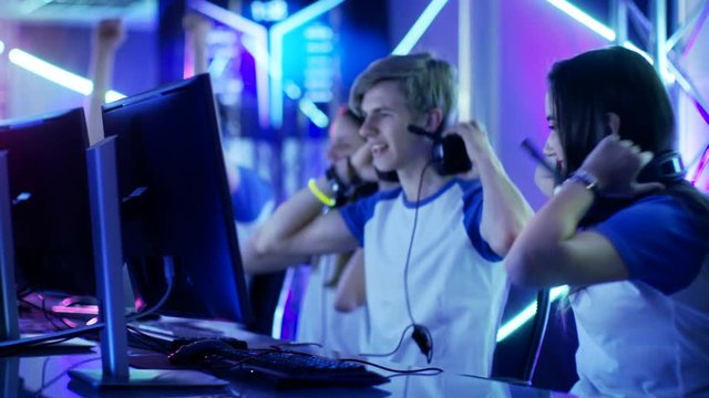Team of Teenage Gamers Win Internet Cafe Online Video Gaming Tournament and Celebrate with High-Fives. Shot on RED EPIC-W 8K Helium Cinema Camera.