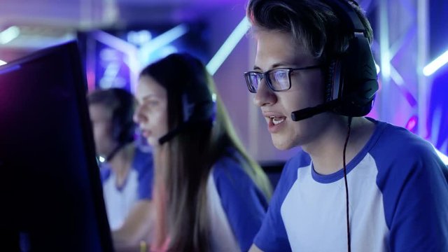 Team of Teenage Gamers Play in Multiplayer  Video Game on a eSport Tournament. Captain Gives Commands into Microphone, Trying Strategically Win the Game. Shot on RED EPIC-W 8K Helium Cinema Camera.