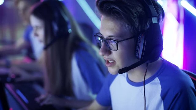  Team of Teenage Gamers Play in Multiplayer PC Video Game on a eSport Tournament. Captain Gives Commands into Microphone, Trying Strategically Win the Game.Shot on RED EPIC-W 8K Helium Cinema Camera.