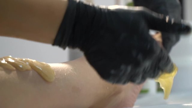 Session shugaring where a girl from her legs pulls out her hair with sugar mass for a shugaring