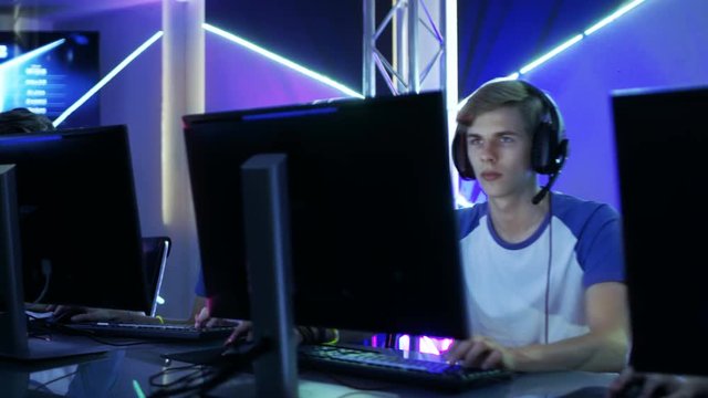 Moving Shot of Team of Teenage Gamers Playing in Multiplayer PC Video Game on a eSport Tournament. Emotionally Charged Moment. Shot on RED EPIC-W 8K Helium Cinema Camera.