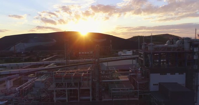 Aerial view Oil refinery with a background of mountains and sky at sunset. Aerial footage.