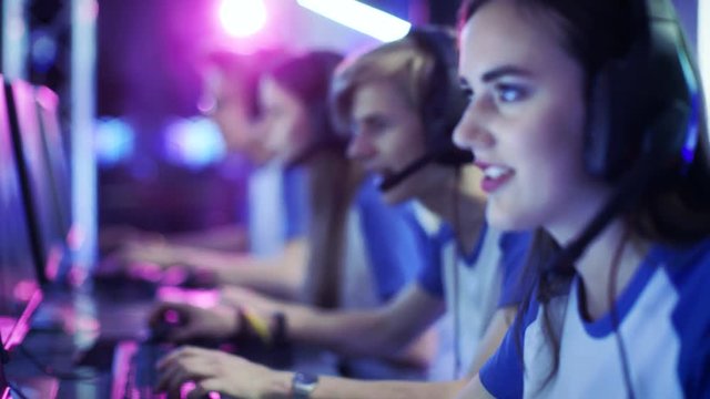 Team of Professional eSport Gamers Playing in Video Games on a Cyber Games Tournament. They Talk to Each other into Microphones. Arena Looks Cool with Neon Lights. 4K UHD.