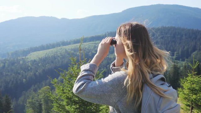 woman standing looking binoculars peak mountain amazing landscape sunny windy freedom flying long hair enjoying trip backpack moving camera around girl hipster traveling back side view healthy sport