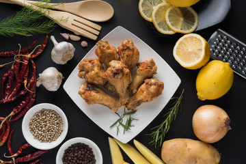 Chicken wing fired with ingredient on black background.