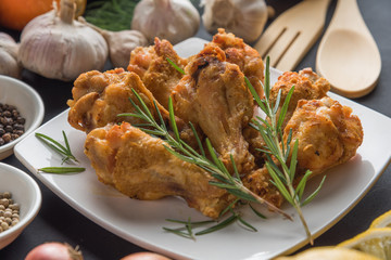 Chicken wing fired with ingredient on black background.