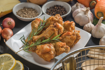 Chicken wing fired with ingredient on black background.