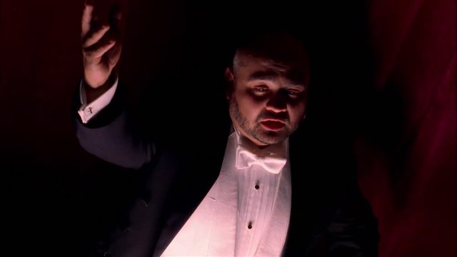 Medium shot of male opera singer onstage.