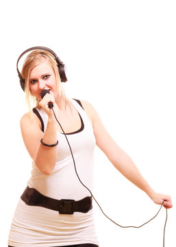 Woman singing to microphone wearing headphones