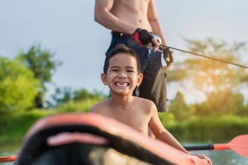 Son and father catch fish from a boat at sunset,a happy time for the holidays.